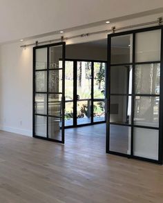 an empty room with sliding glass doors and hard wood flooring