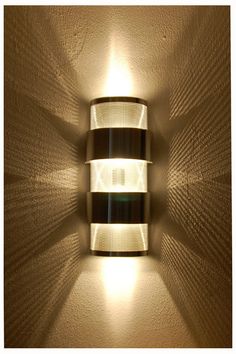 a wall light that is on the side of a wall in a room with no one around it