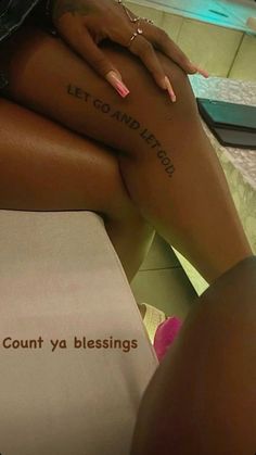 a woman sitting on top of a bed with her legs crossed and the words let go and let go written on her leg