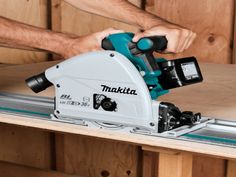 a man uses a makita circular saw to cut wood with a miter