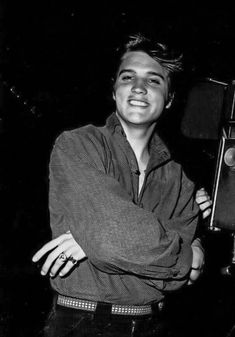 black and white photograph of a man holding an old fashioned camera in front of him