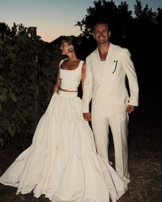 a man and woman dressed in white standing next to each other