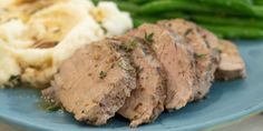 a blue plate topped with meat, mashed potatoes and green beans