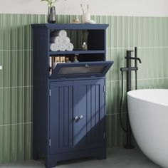 a white bath tub sitting next to a blue cabinet