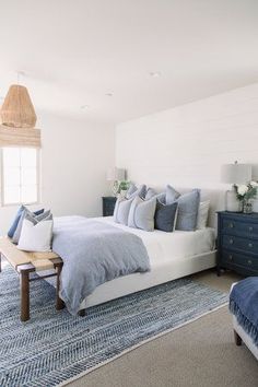 a bed room with a neatly made bed next to a dresser and window in it