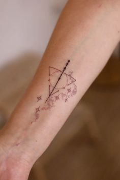 a person's arm with a tattoo on it and stars in the sky behind them