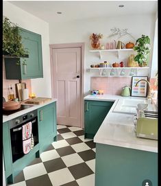 a kitchen with green cabinets and checkered flooring on the floor, along with an oven