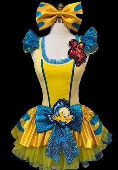 a yellow and blue dress with an image of the character pooh bear on it