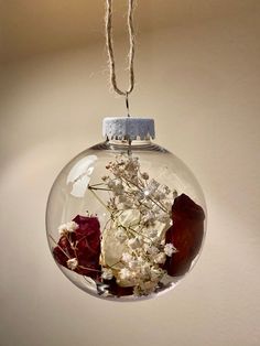 a glass ornament with dried flowers in it