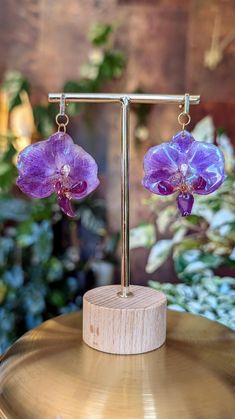 Celebrate your style - be unique ✨ With these magical real orchid earrings, which preserve the beauty of nature, you will make every outfit a highlight and attract attention! These pieces of jewelry are made by hand from start to finish by myself. Starting with the collection and drying of the flowers, which become more fragile than parchment paper after weeks of storage. These are then delicately sealed with resin by hand, layer by layer - and the whole process is repeated 3-4 times until they Elegant Purple Pressed Flower Earrings, Purple Flower-shaped Whimsical Jewelry, Whimsical Purple Flower Jewelry, Purple Birth Flower Drop Earrings, Whimsical Purple Flower-shaped Jewelry, Purple Flower-shaped Earrings, Purple Bohemian Flower Earrings For Gift, Purple Bohemian Flower Earrings As Gift, Handmade Orchid Earrings