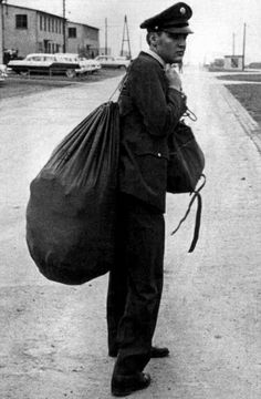 an old black and white photo of a man with a bag