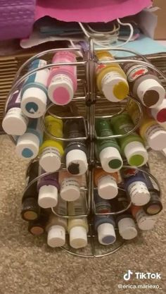 a rack filled with lots of different colored bottles on top of a carpeted floor