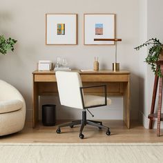 a chair and desk in a room with two framed pictures on the wall above it