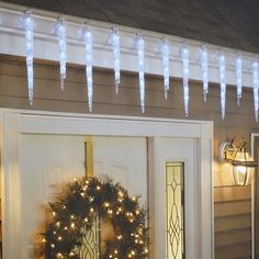 the front door is decorated with christmas lights and wreaths for holiday decorations, including icicles