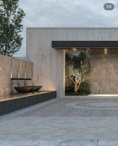 an entrance to a building with stone walls and plants on the outside, surrounded by concrete steps