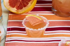 a grapefruit cocktail with orange slices and garnish on a striped table cloth