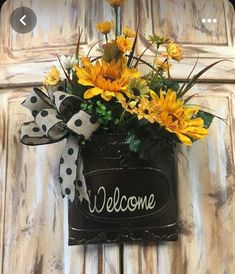 a welcome sign with yellow flowers in it