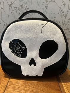 Skull bag ( carbon chic design) with long adjustable strap. The bag is made from vegan friendly faux leather and cotton liner. This is soft yet holds it's shape. The double zip pull on the top is an excellent addition. Bag zip pocket and an internal zip pocket gives you lots of secure spaces. This bag also has some lovely metal feet to save the bottom of your bag from wear and tear. The size is approximately 22cm tall by 23 cm wide and 10 cm deep. It's a cute bag. I will be making more that's fo Black Zipper Closure Shoulder Bag For Halloween, Black Skull Bag For Halloween, Black Skull-shaped Bag For Halloween, Black Skull-shaped Bag With Skull Print, Black Skull Print Bag For Halloween, Black Halloween Bag With Skull Print, Halloween Skull Print Travel Bag, Black Halloween Bags With Skull Print, Purple Skull