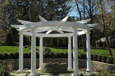 a white pergolated structure in the middle of a park