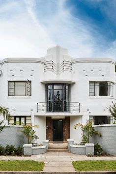 a large white building with two balconies on the front and second story windows