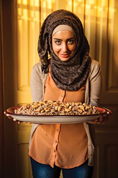 a woman holding a platter of food in front of her face