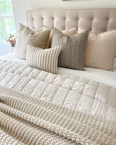 a bed with several pillows on top of it