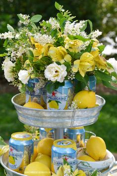 two tiered tray with lemons and white flowers in cans on top of it