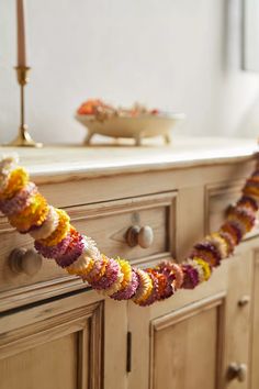 a garland is hanging from the side of a dresser