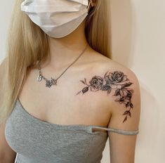 a woman wearing a face mask with flowers on her shoulder and chest tattooing it