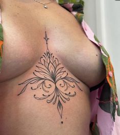 an image of a woman's breast with tattoos on her chest and the bottom part of her stomach