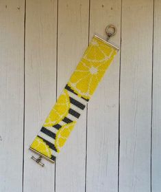 a yellow and black keychain hanging on a white wooden wall