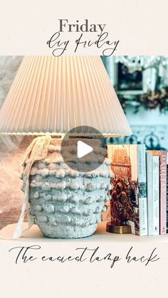 a lamp sitting on top of a table next to a bookshelf and a book