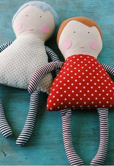 two dolls laying on top of each other in red and white polka dot fabric,