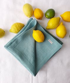 lemons and limes are scattered around a napkin