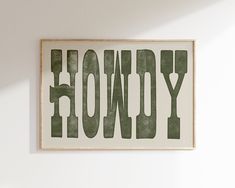 a sign that says honey hanging on the wall in front of a white wall with green lettering