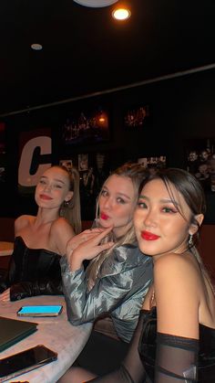 three beautiful women sitting at a table together