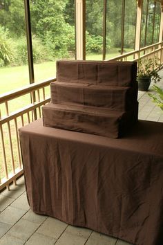 a stack of brown sheets sitting on top of a wooden table next to a window