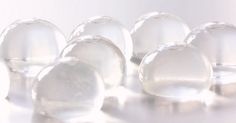 several clear glass objects on a white surface