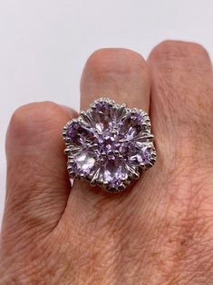 This is a vintage purple amethyst flower ring   set in 925 sterling We have in size 6.5  this can be sized to your specification, our jeweler charges $20 please message us to discuss sizing your ring or engraving options. All of our jewelry is hand polished and shipped to you in a stylish gift box.  We are happy to gift wrap for you.  It is important to us that each customer be thrilled with their purchase.  We are grateful for thousands of positive reviews. Elegant Purple Flower Ring As A Gift, Elegant Purple Flower Ring For Gift, Elegant Purple Flower Ring As Gift, Elegant Purple Flower Ring, Flower Shaped Amethyst Jewelry For Anniversary, Elegant Purple Gemstone Flower Ring, Purple Flower Ring For Anniversary, Elegant Purple Amethyst Flower Ring, Formal Flower Ring Stamped 925