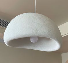 a white light hanging from the ceiling in a room