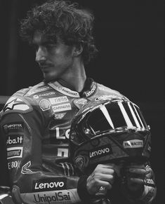 a black and white photo of a man wearing a motorcycle helmet with long curly hair