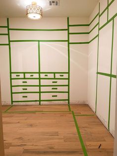 an empty room with green lines painted on the walls and wood flooring in it