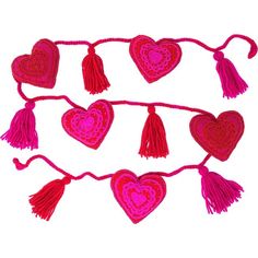 red crocheted hearts with tassels hanging on a string against a white background