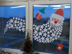 two windows decorated with christmas decorations and santa clause