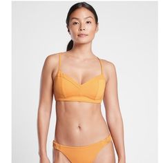 Nwt Athleta Sculpted Bikini Top Color: Abyssinian Yellow New With Tags. No Marks, Odors, Flaws, Or Defects. * Lycra Xtra Lifem Spandex. Ultra-Resilient Fabric Snaps Back Like A Pro And Lasts 5 To 10x Longer * Wireless Sling Support Provides A Comfortable, Flattering Fit With Additional Lift And Shape * Premium Liner For Shaping And Support * Adjustable X Back Straps * Lightweight, Removable Pads * #530886 Light Support: Best For A-C Cups Mid Coverage Neckline Shell: 80% Nylon / 20% Spandex Linin Athleisure Triangle Top Swimwear, Sporty Yellow Swimwear For Workout, Sporty Yellow Workout Swimwear, Yellow Summer Swimwear For Sports, Yellow Summer Sports Swimwear, Matching Swimwear, Snap Backs, Like A Pro, Back Strap