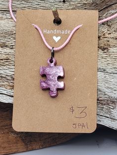 This fun necklace features a pink resin puzzle piece pendant. Pink pigments were used in the resin mold. The puzzle piece is ¾” W x 1 15/16” H. The pendant is attached to a 17.5” cord with lobster clasp, extendable up to 19.5”. Product Weight: 0.14 oz Resin Puzzle, Puzzle Piece Necklace, Puzzle Jewelry, Handcrafted Ornaments, Wood Project, Christmas Favorites, Puzzle Piece, Cool Necklaces, Resin Molds