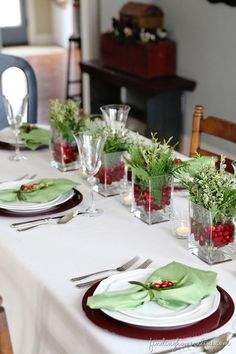 the table is set with white and green place settings