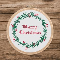 a cross stitch christmas wreath with the words merry christmas on it