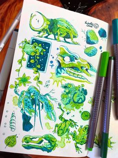 an open notebook with green and blue drawings on it