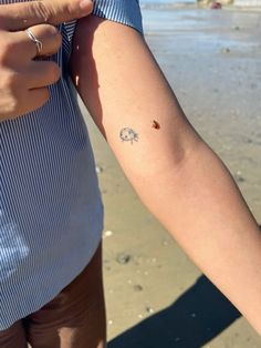 a person with a small tattoo on their arm holding onto another person's arm